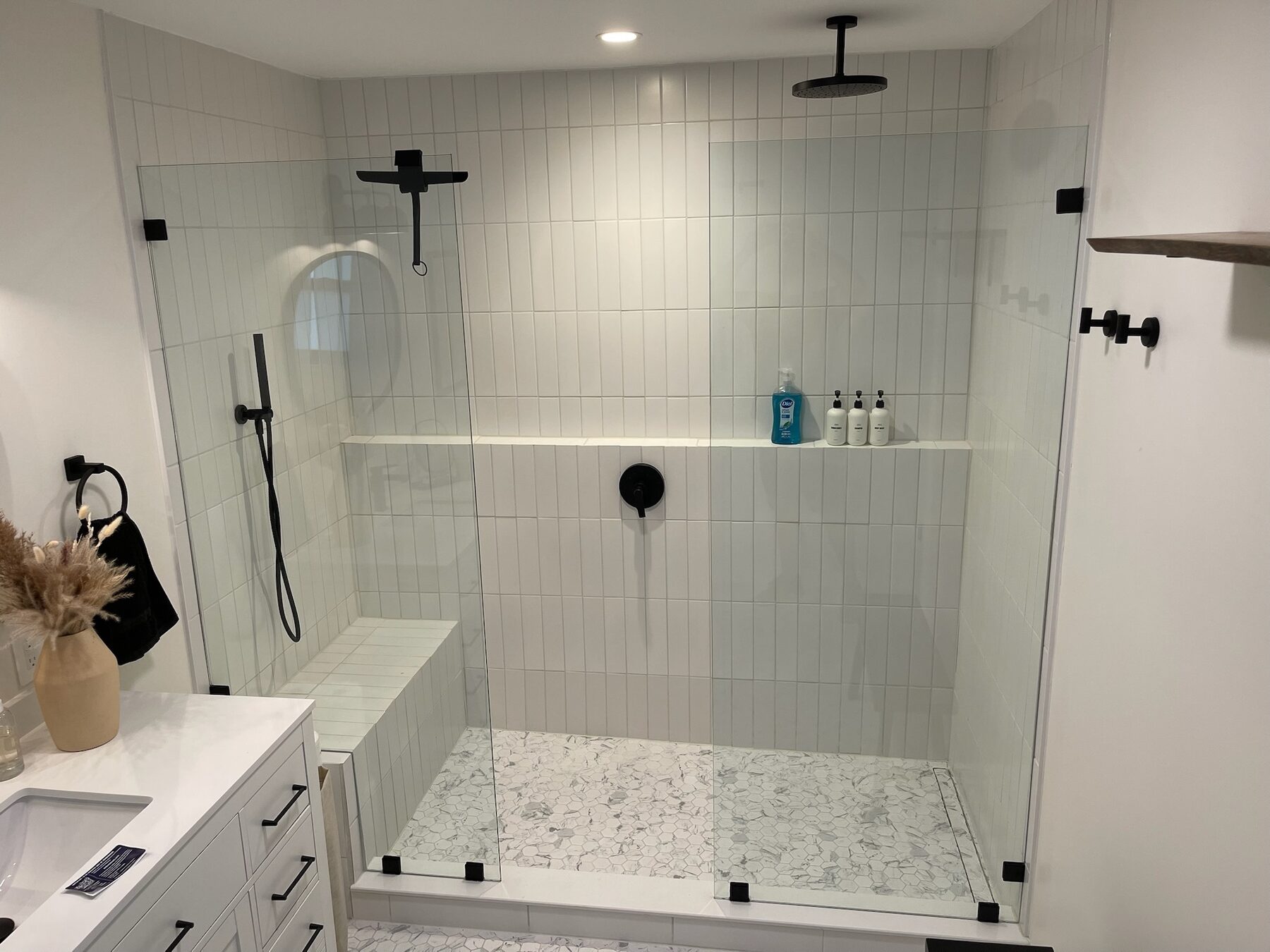 Wide frameless shower enclosure with black hardware